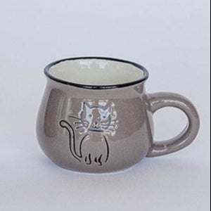 Three brown ceramic mugs with cat designs on a white background