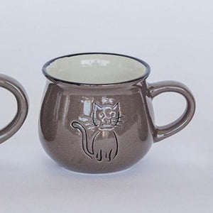 Three brown ceramic mugs with cat designs on a white background