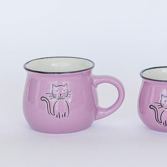 Three pink mugs with cat designs on a white background