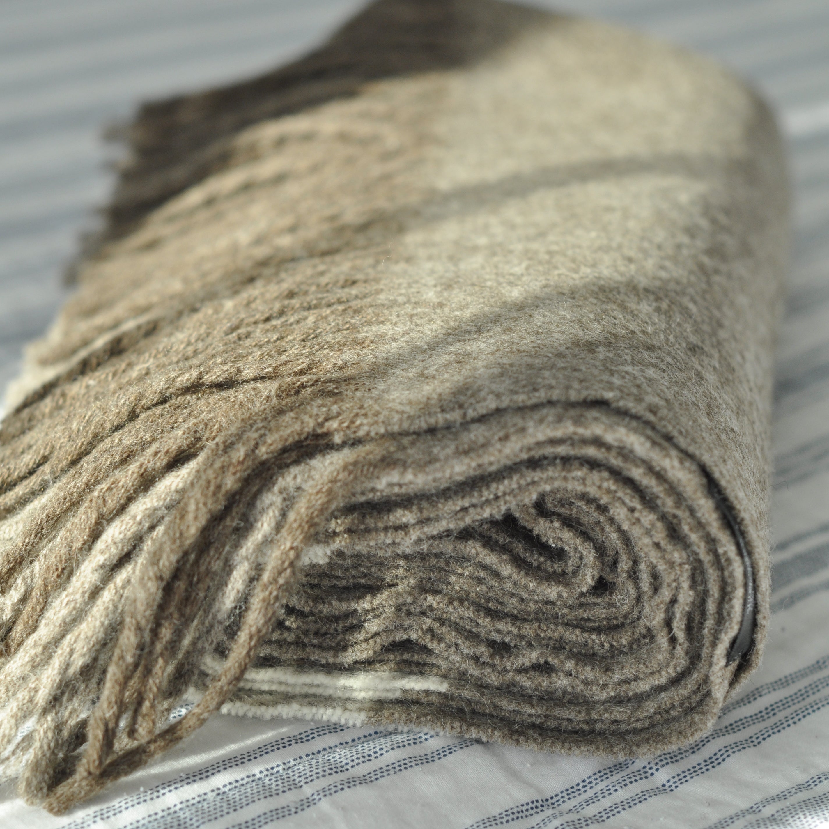 Rolled-up beige carpet on a striped surface