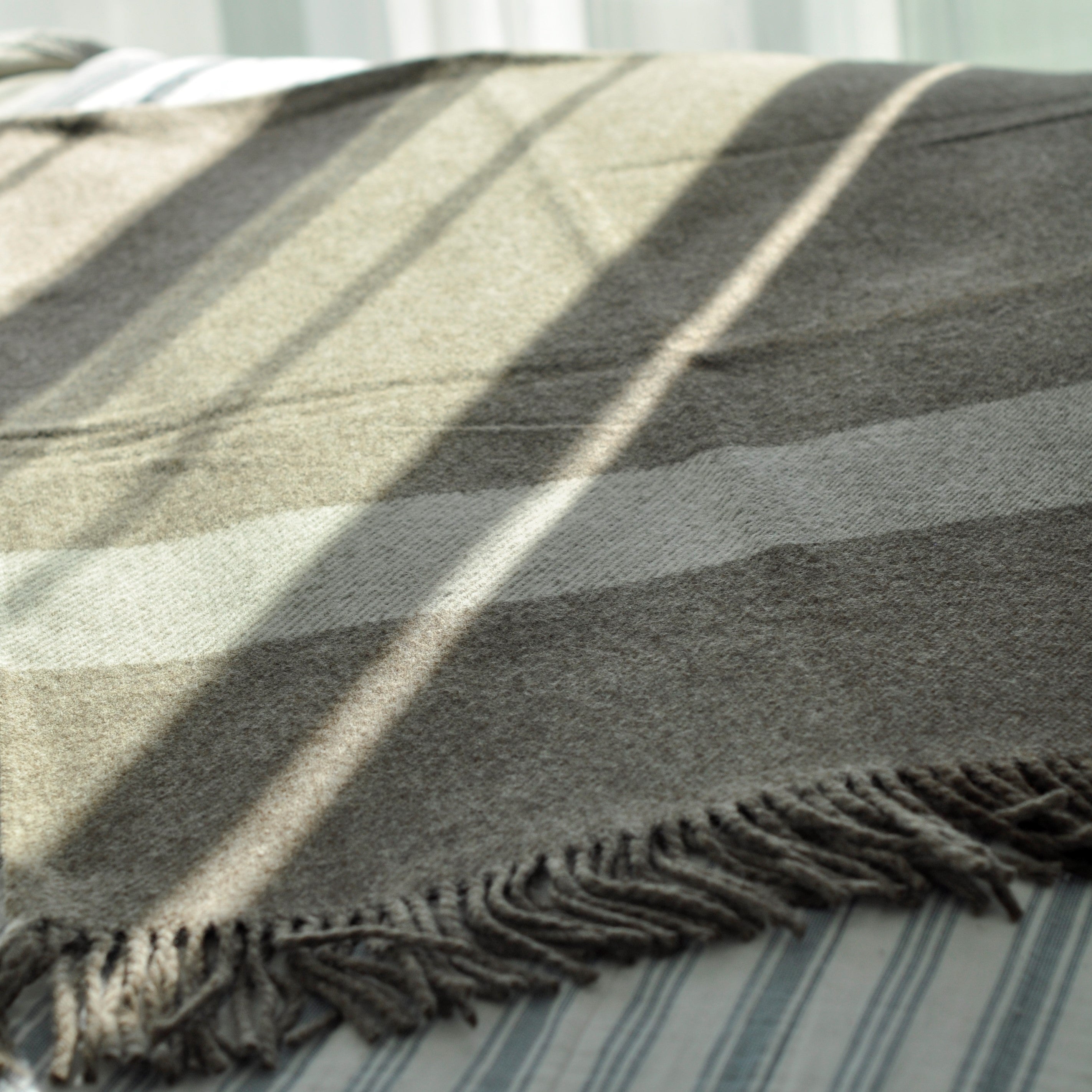 Striped blanket with frayed edge on a surface
