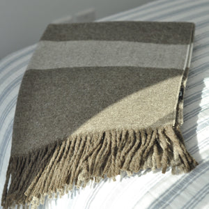Striped blanket with fringes on a striped surface