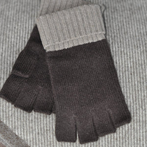 A person wearing a beige and brown cashmere beanie with a fur pom pom, and matching fingerless gloves.