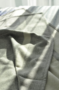 Close-up of a gray garment with a striped pattern on a blurred background