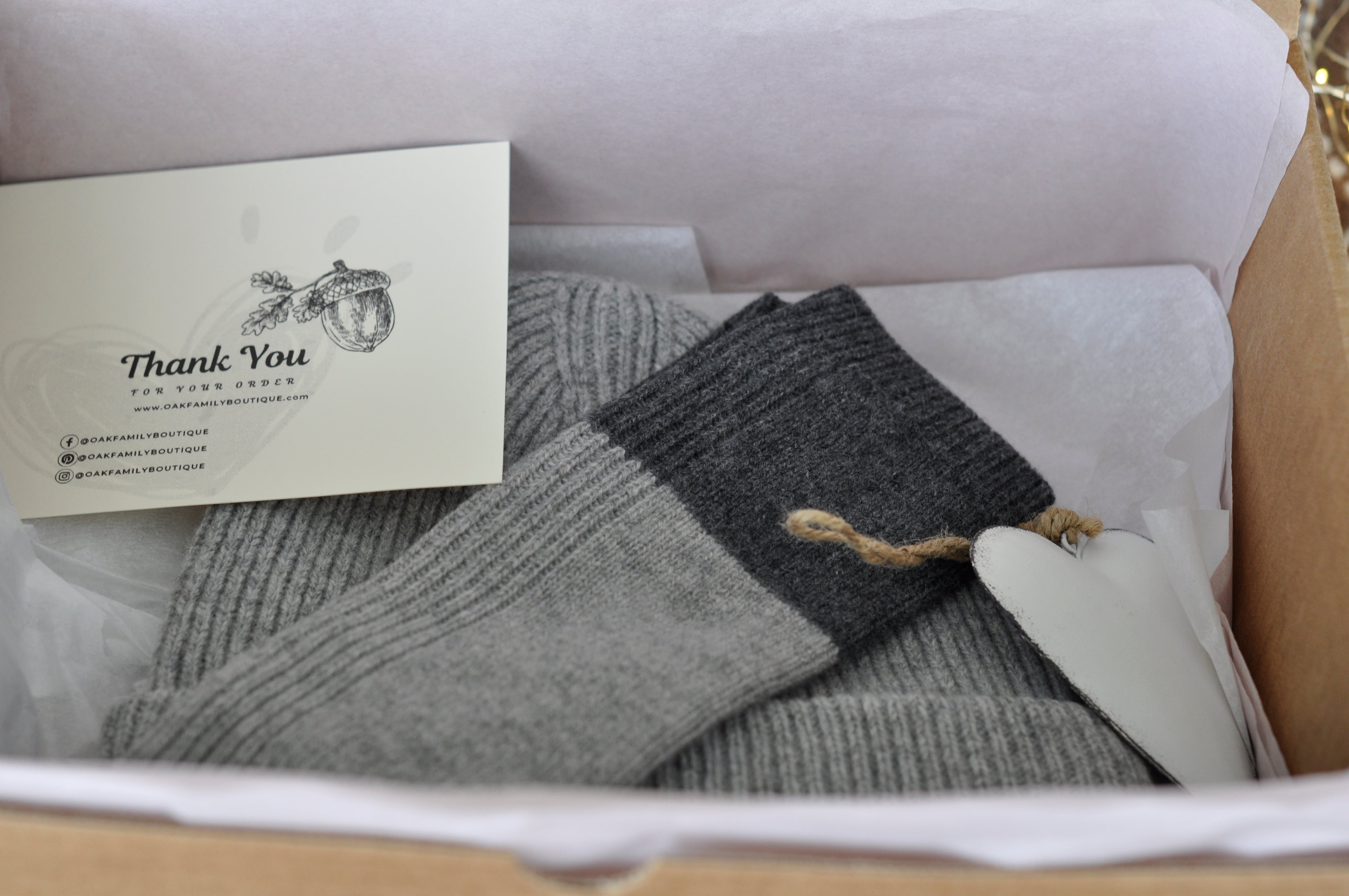 Gray and black knit socks with a 'Thank You' card in a box