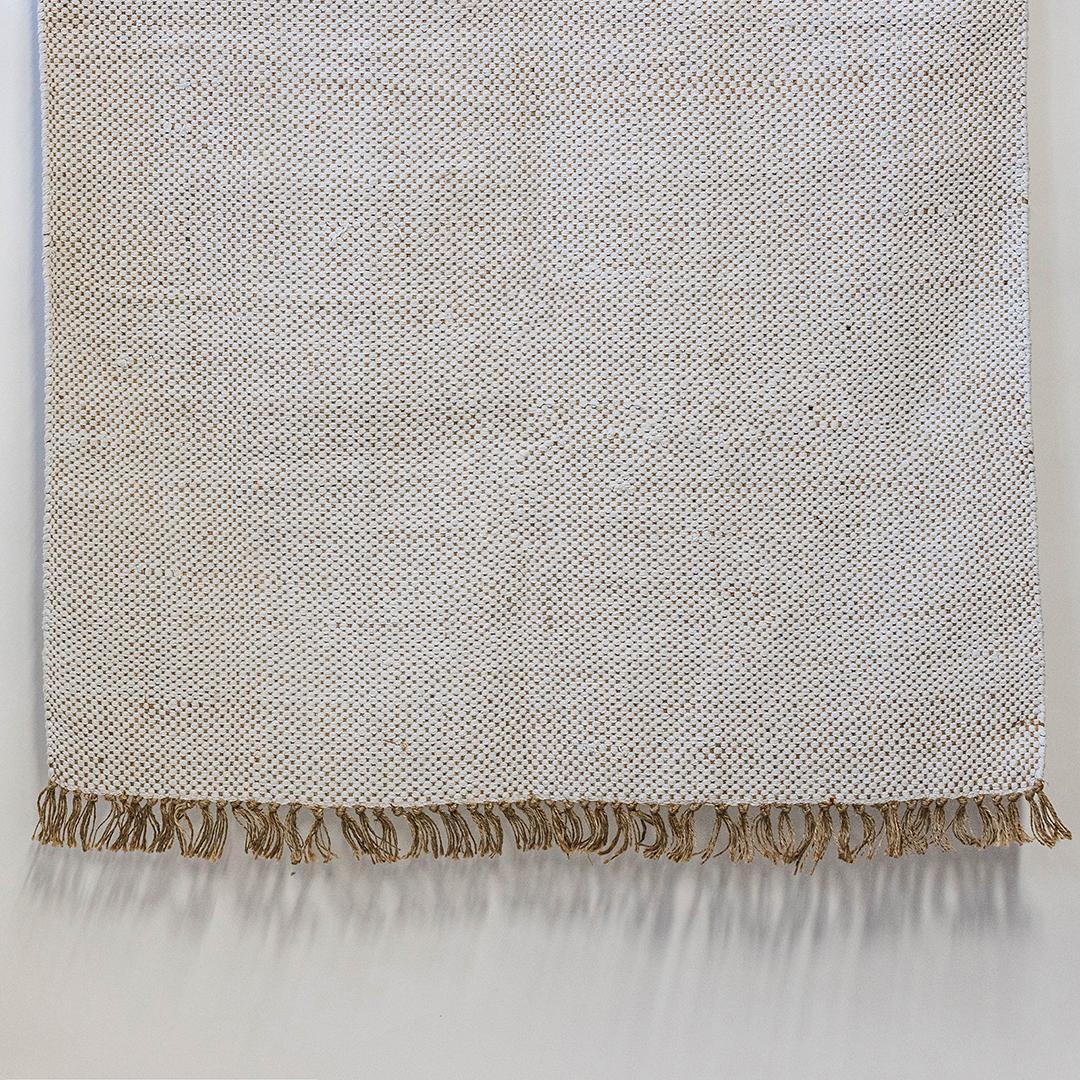 Textured blanket with frayed edge on a light gray background