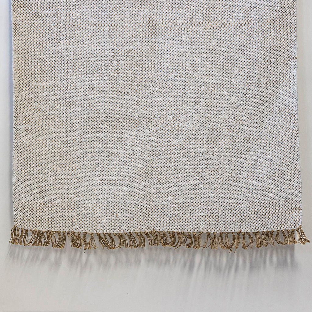 Textured blanket with frayed edge on a light gray background