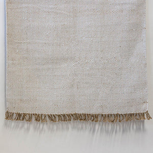 Textured blanket with frayed edge on a light gray background