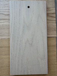 Wooden cutting board with a small hole on a wooden surface