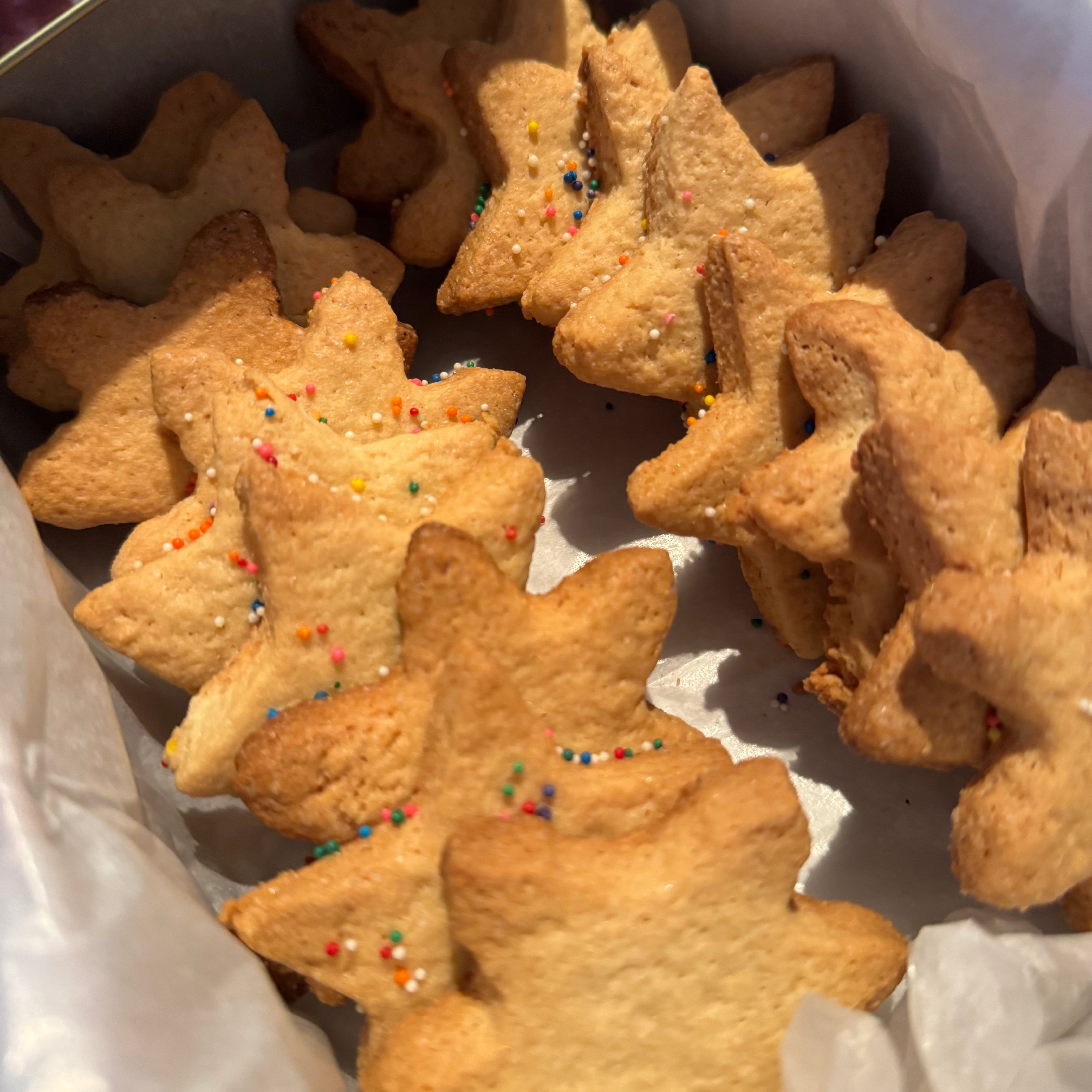Star-shaped cookies with colorful sprinkles on a white surface
