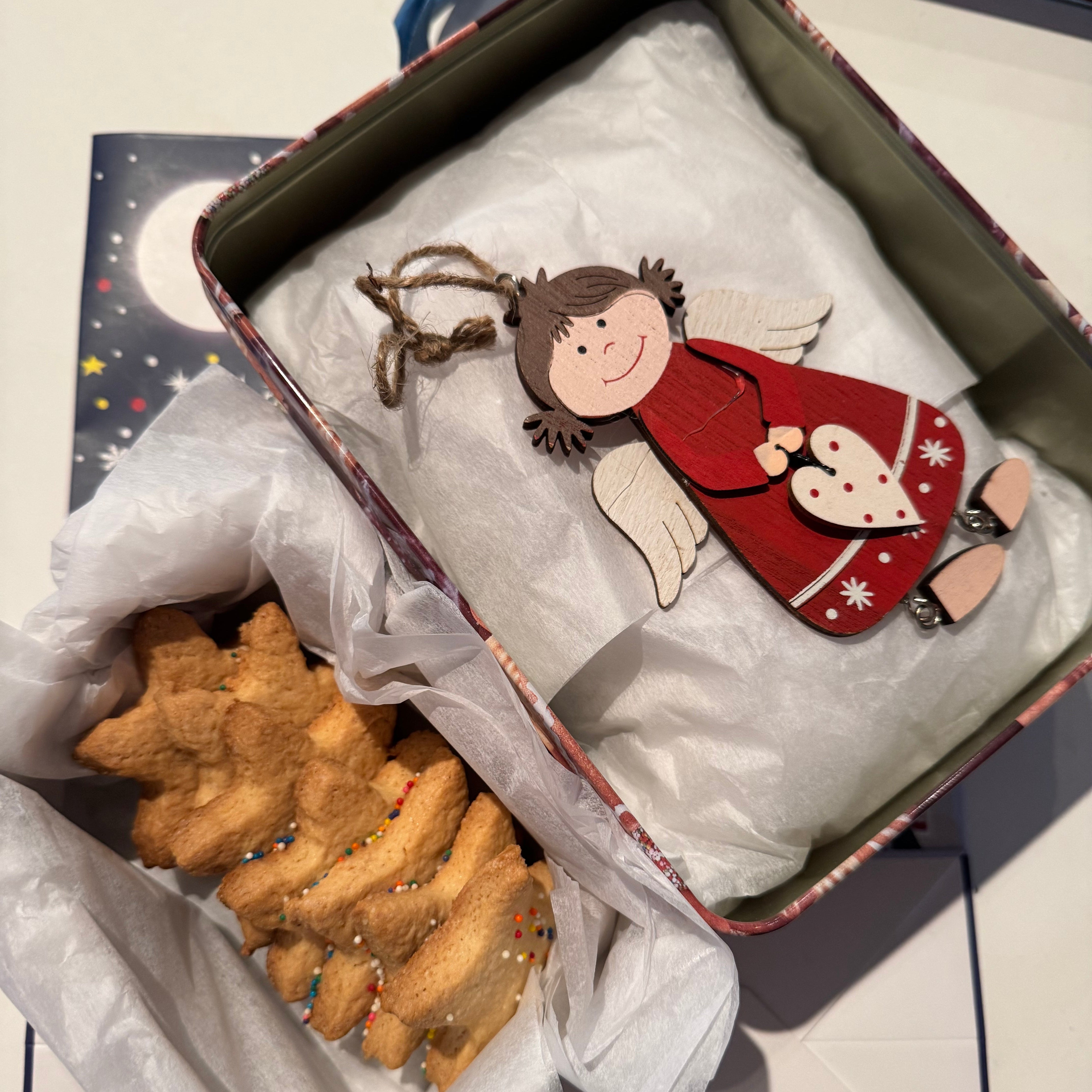 Decorative angel ornament in a box with cookies