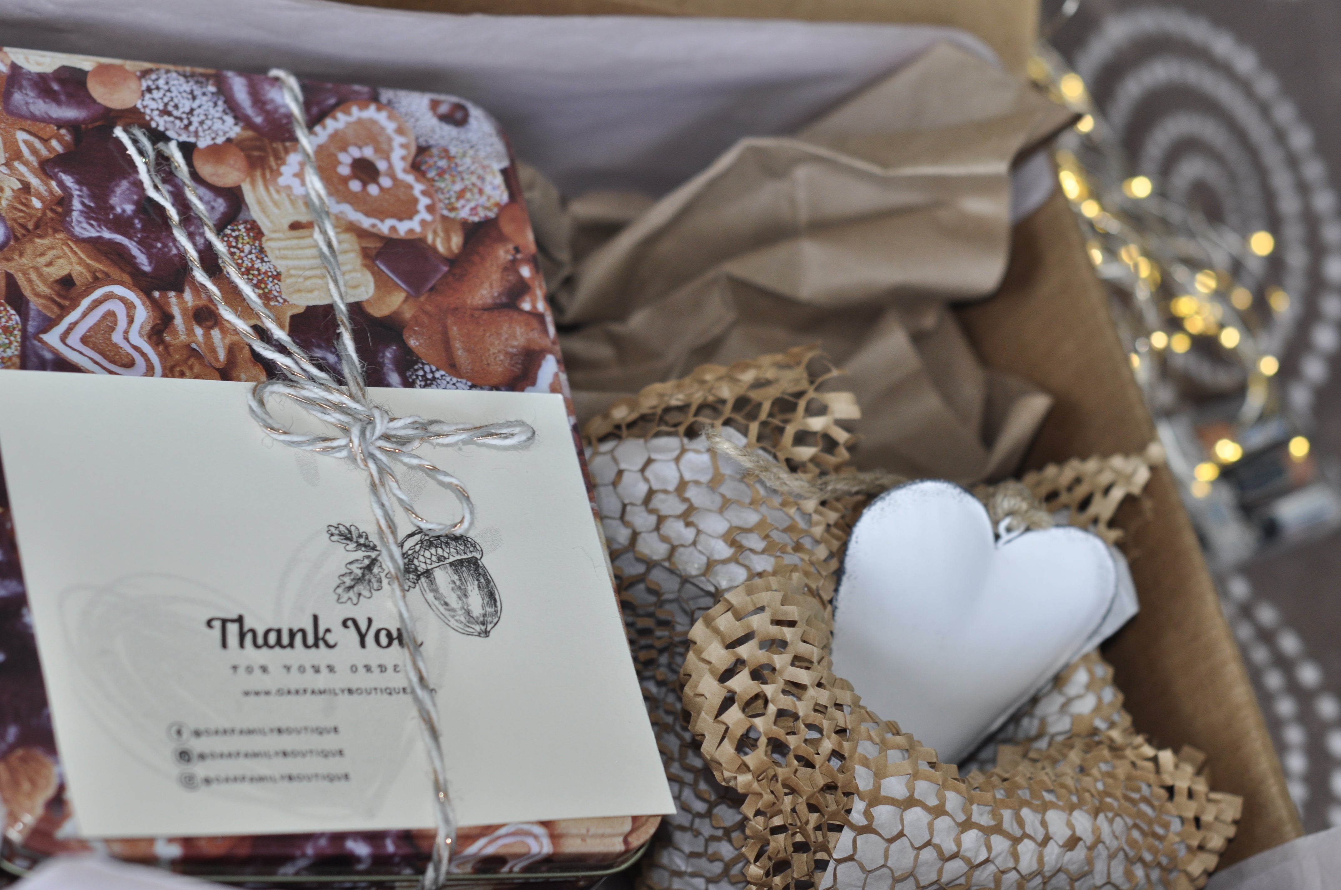 Gift box with a book, card, and decorative heart on a textured surface.