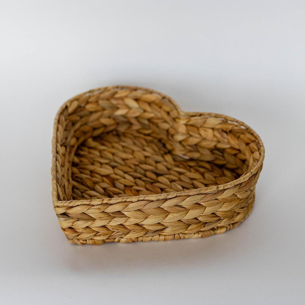 Heart-shaped woven basket on a white background