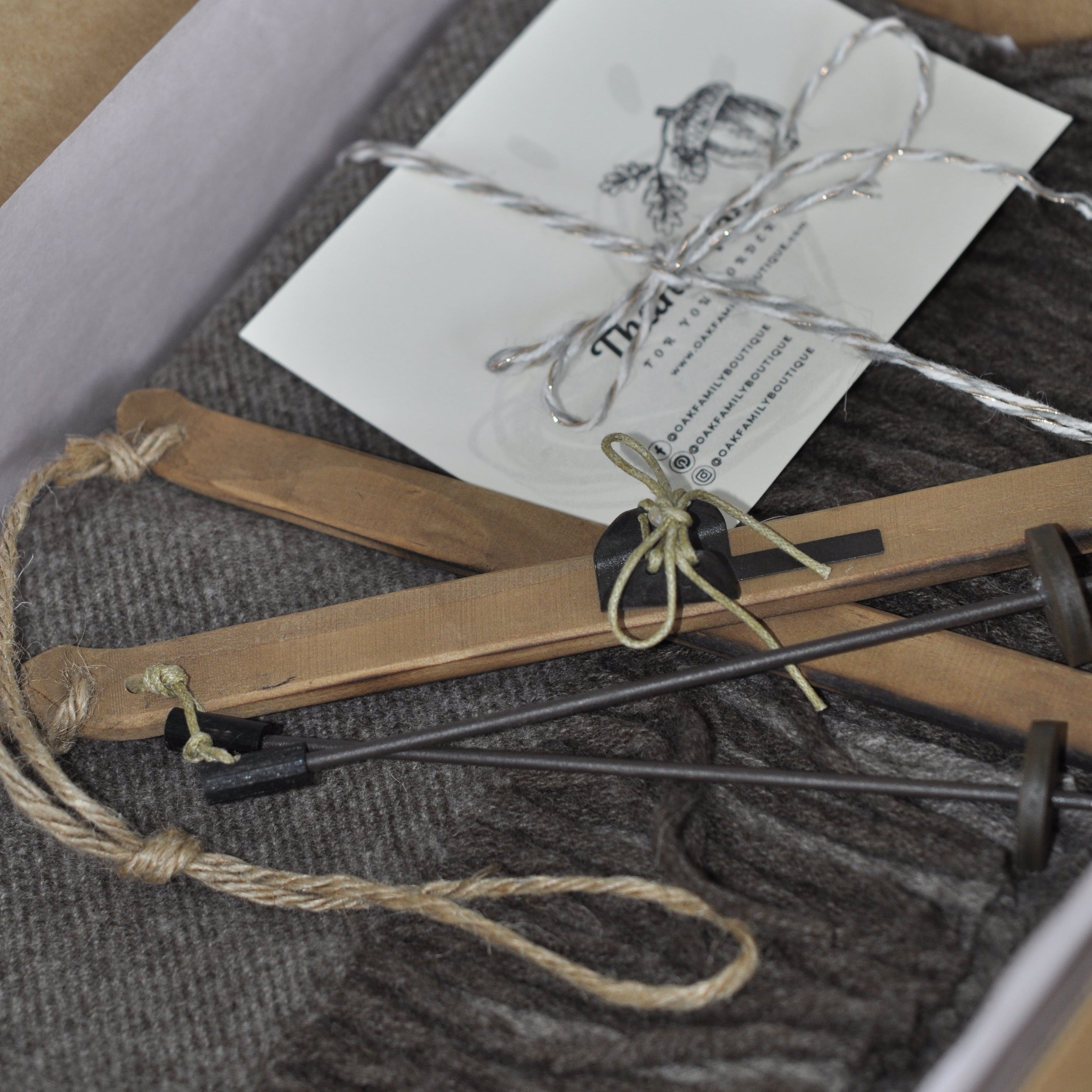 Decorative items including twine, a card with an illustration, and a small box on a textured surface.