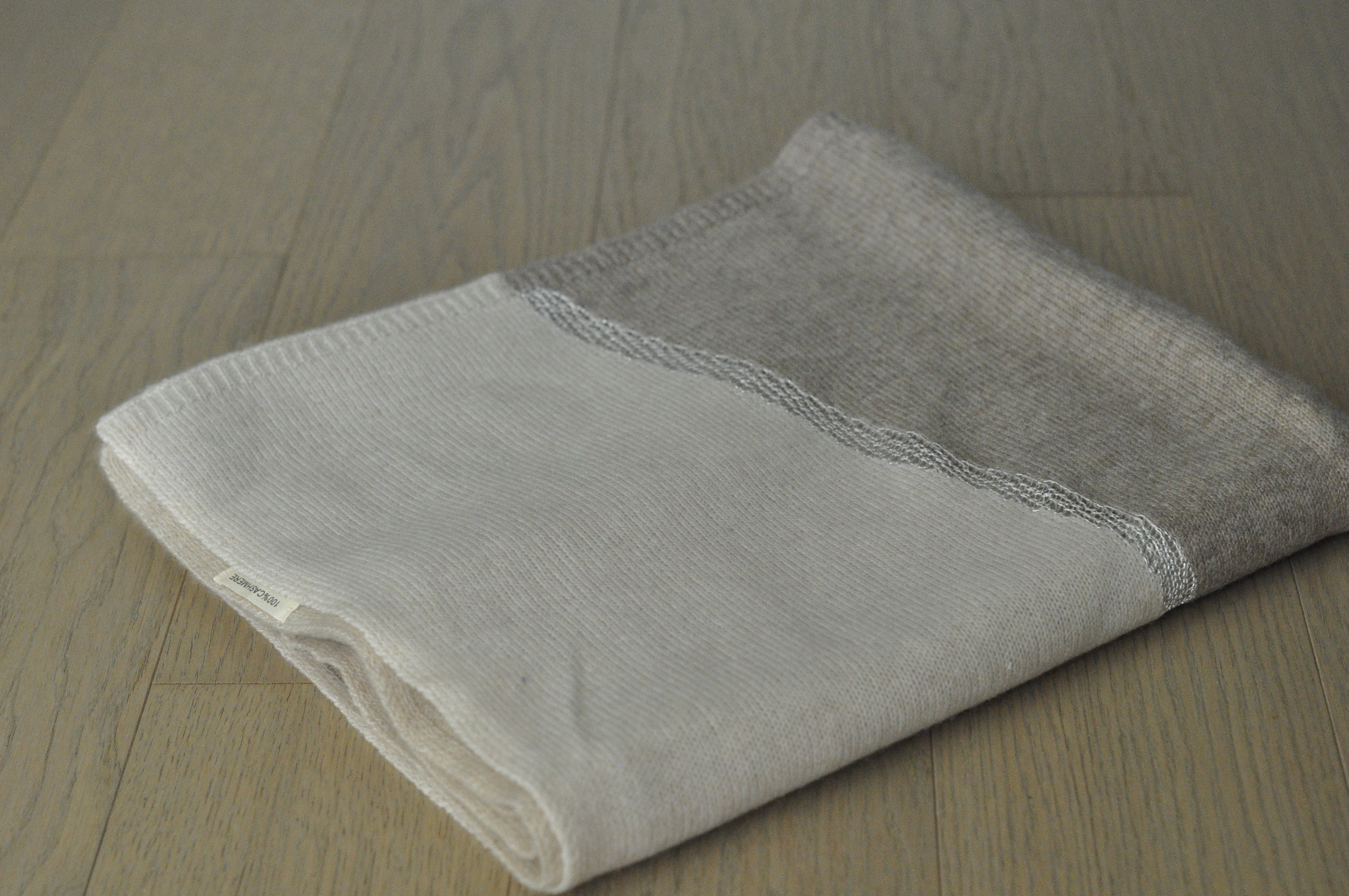 charming cashmere shawl and white fabric on a wooden surface